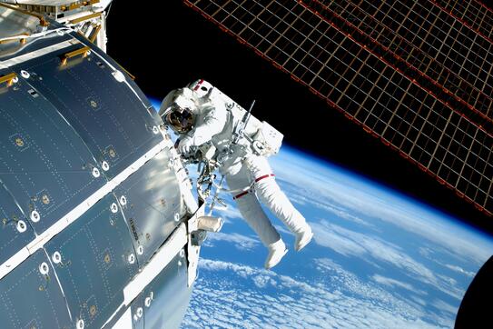 Astronaut in space, at the ISS, repairs and makes experiments. 